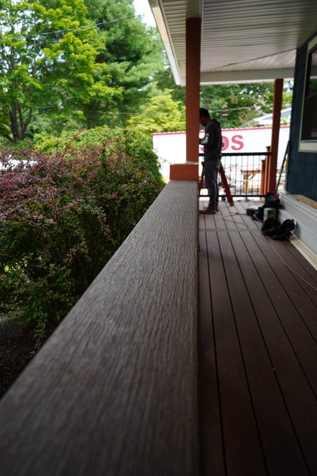 Composite deck railing run with black balusters overlooking the yard
