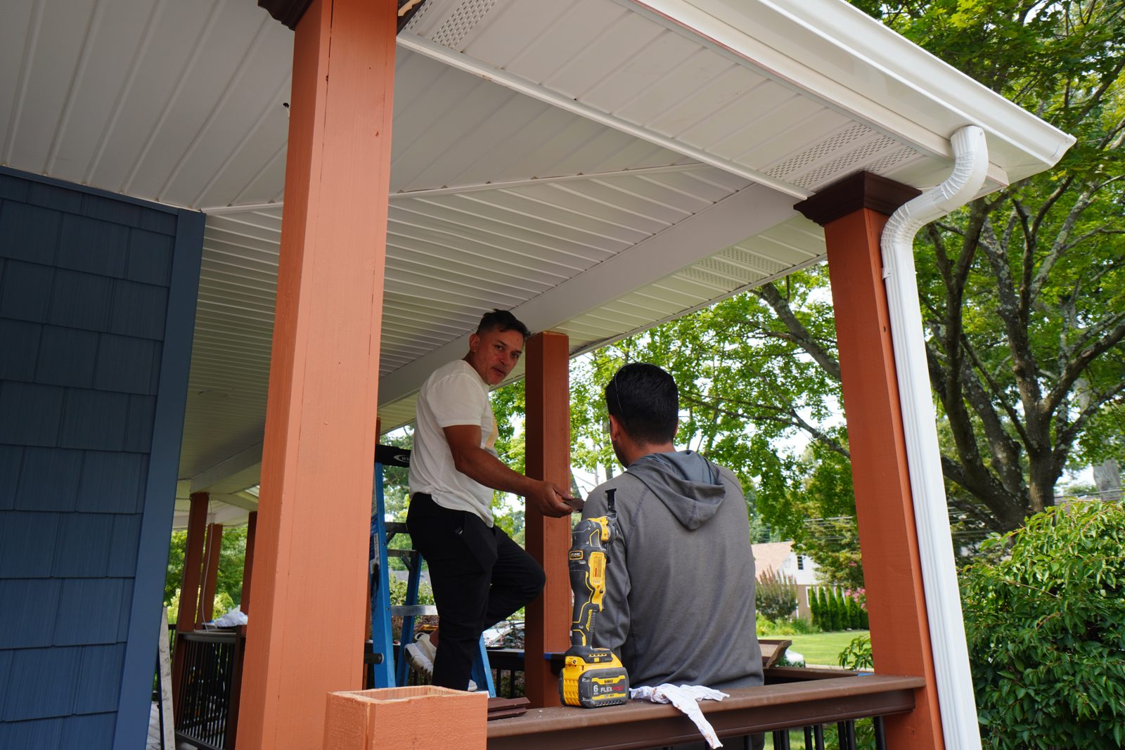 Crew installing porch columns and railings on the wraparound porch