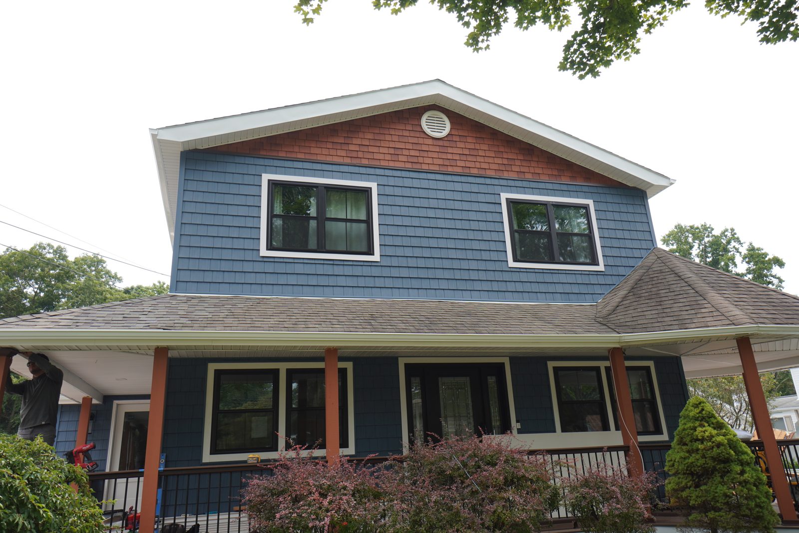 Front elevation with new vinyl siding, windows, and white frame trim