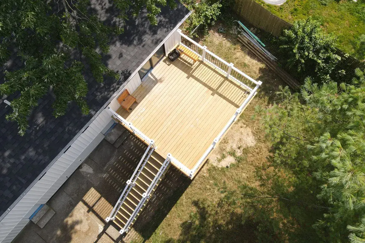 Aerial view of a rebuilt deck with vinyl railing by Alec's Construction