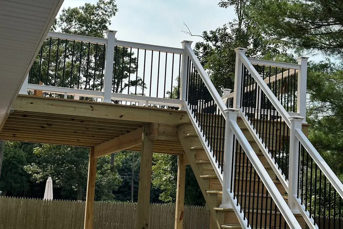 Pressure-treated deck framing and stairs with vinyl railing by Alec's Construction