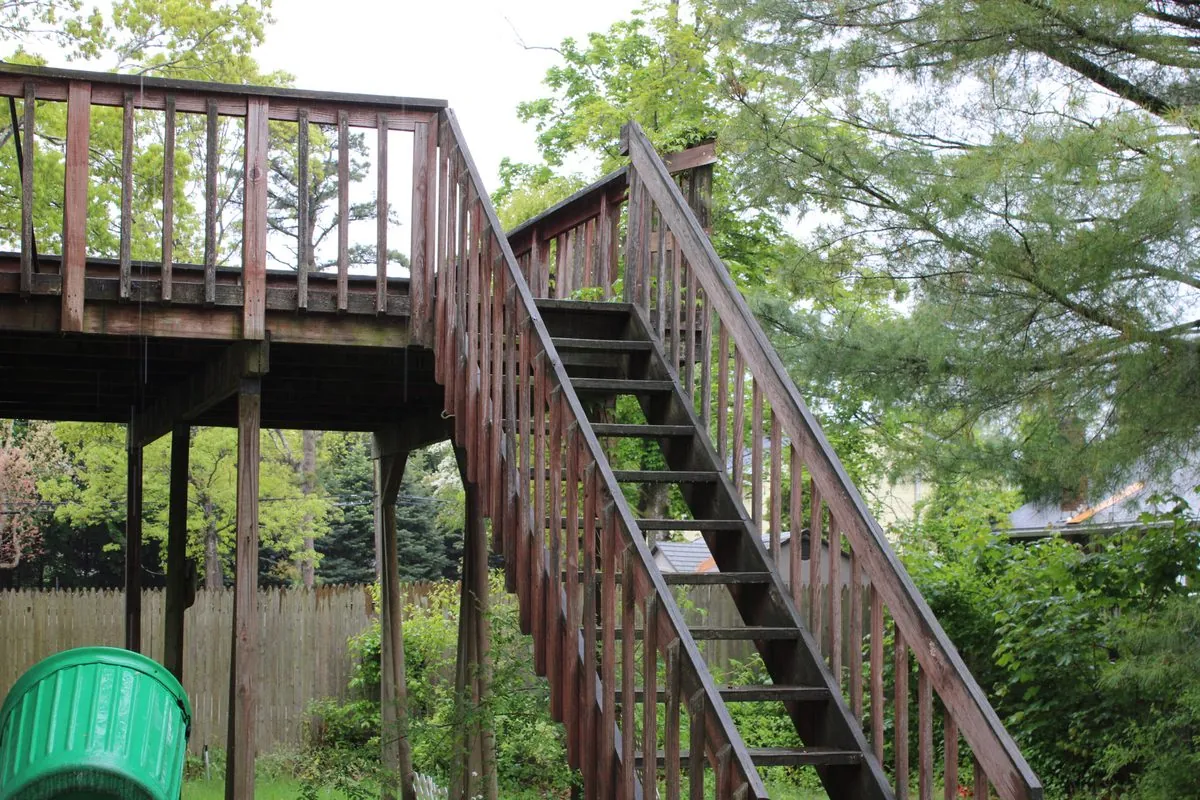 Rotted elevated wood deck and stair run before replacement by Alec's Construction