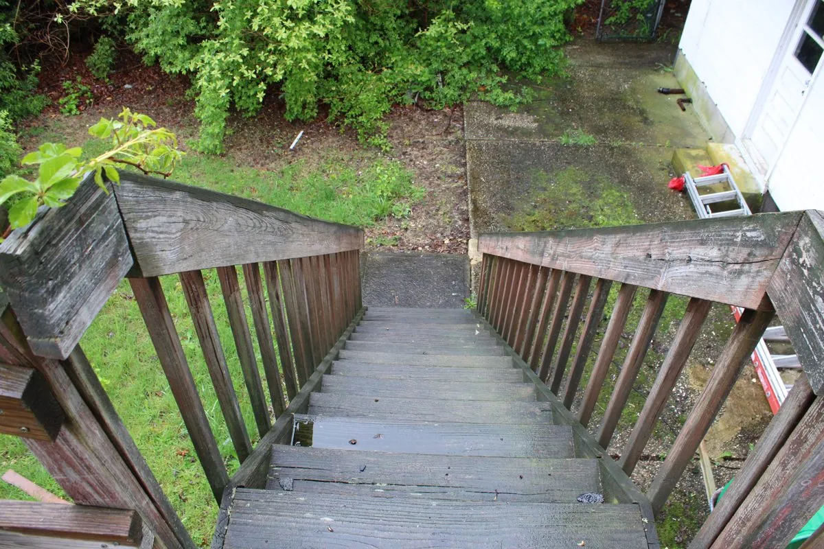 Overhead view of decayed untreated deck boards before rebuild by Alec's Construction
