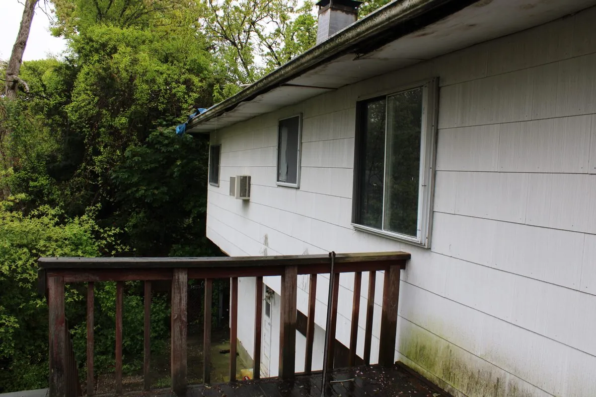 Weathered wood deck railing showing rot before repair by Alec's Construction