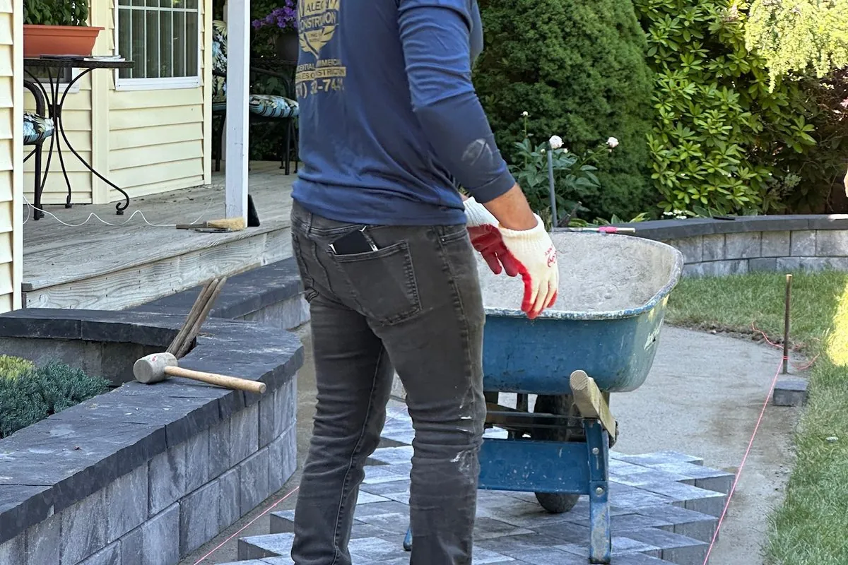 Alec's Construction crew laying pavers over a stone step landing
