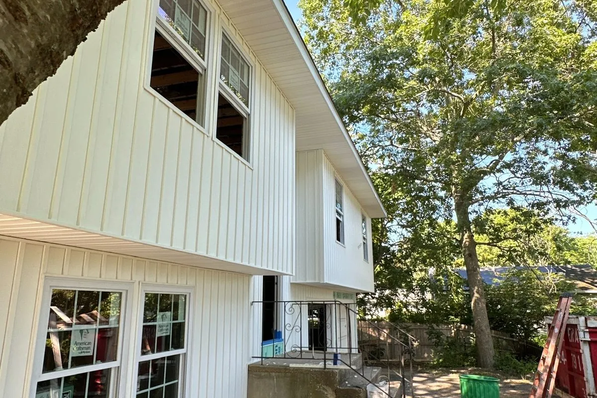 White board-and-batten siding with new windows by Alec's Construction