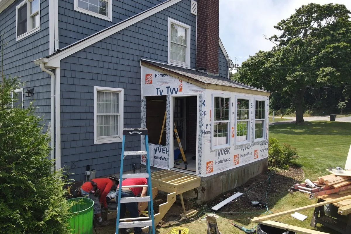 Sunroom addition mid-build with house wrap and new windows by Alec's Construction